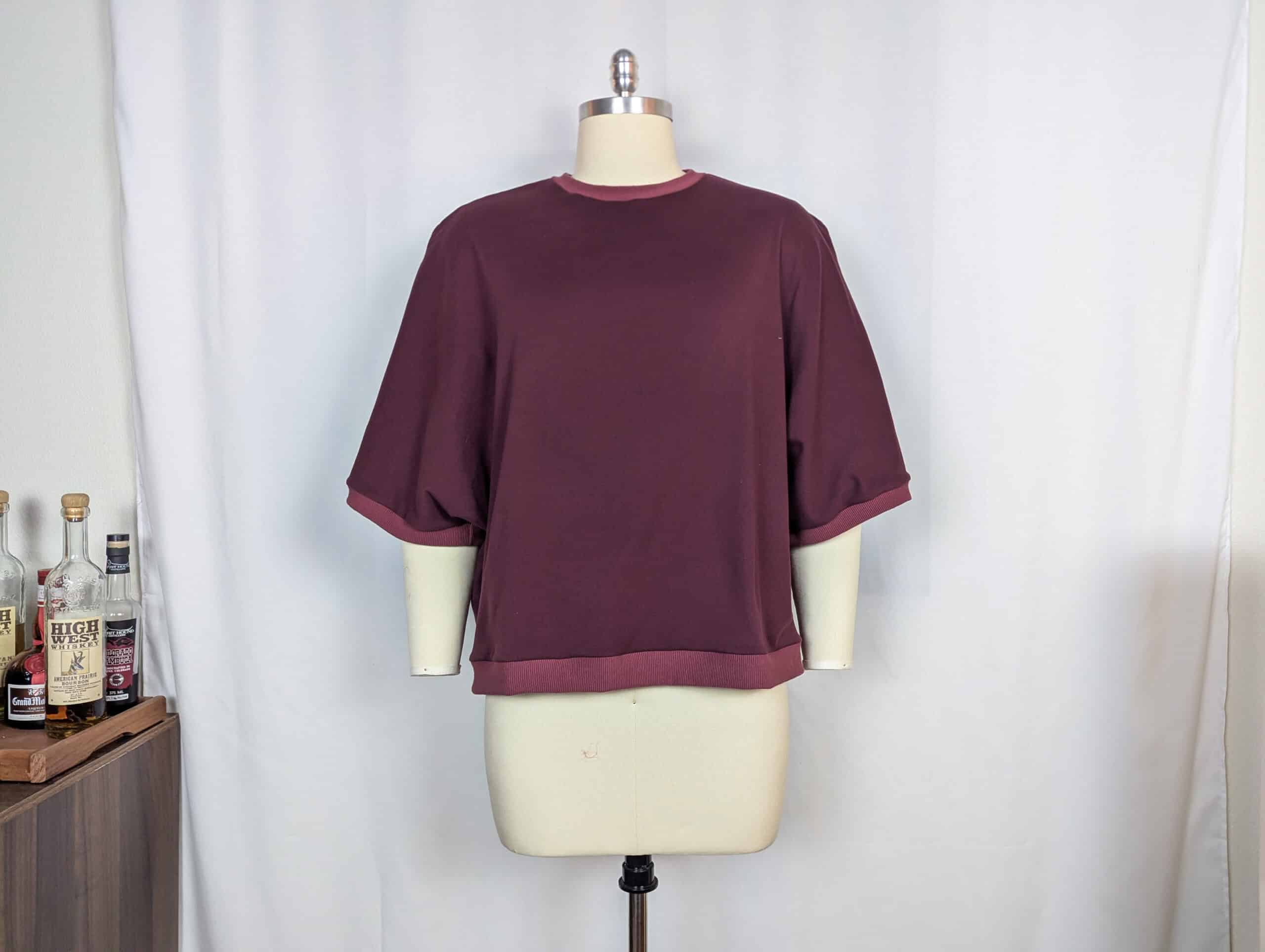 Burgundy sewist top displayed on mannequin for sewing and fashion enthusiasts.