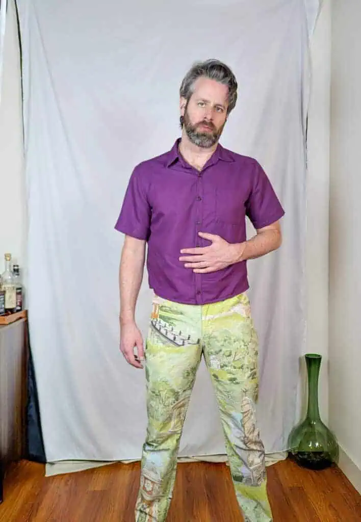 Man wearing a purple short-sleeve shirt with a classic collar and button front.