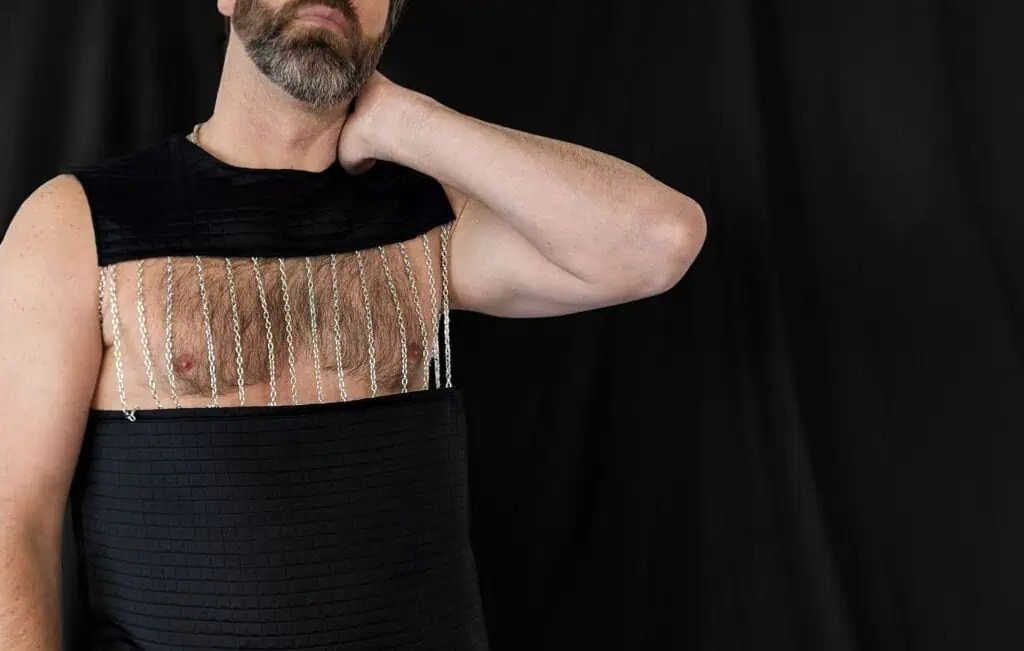 Sleeveless men's top with sheer fabric and vertical bead embellishments, black color, fitted style.