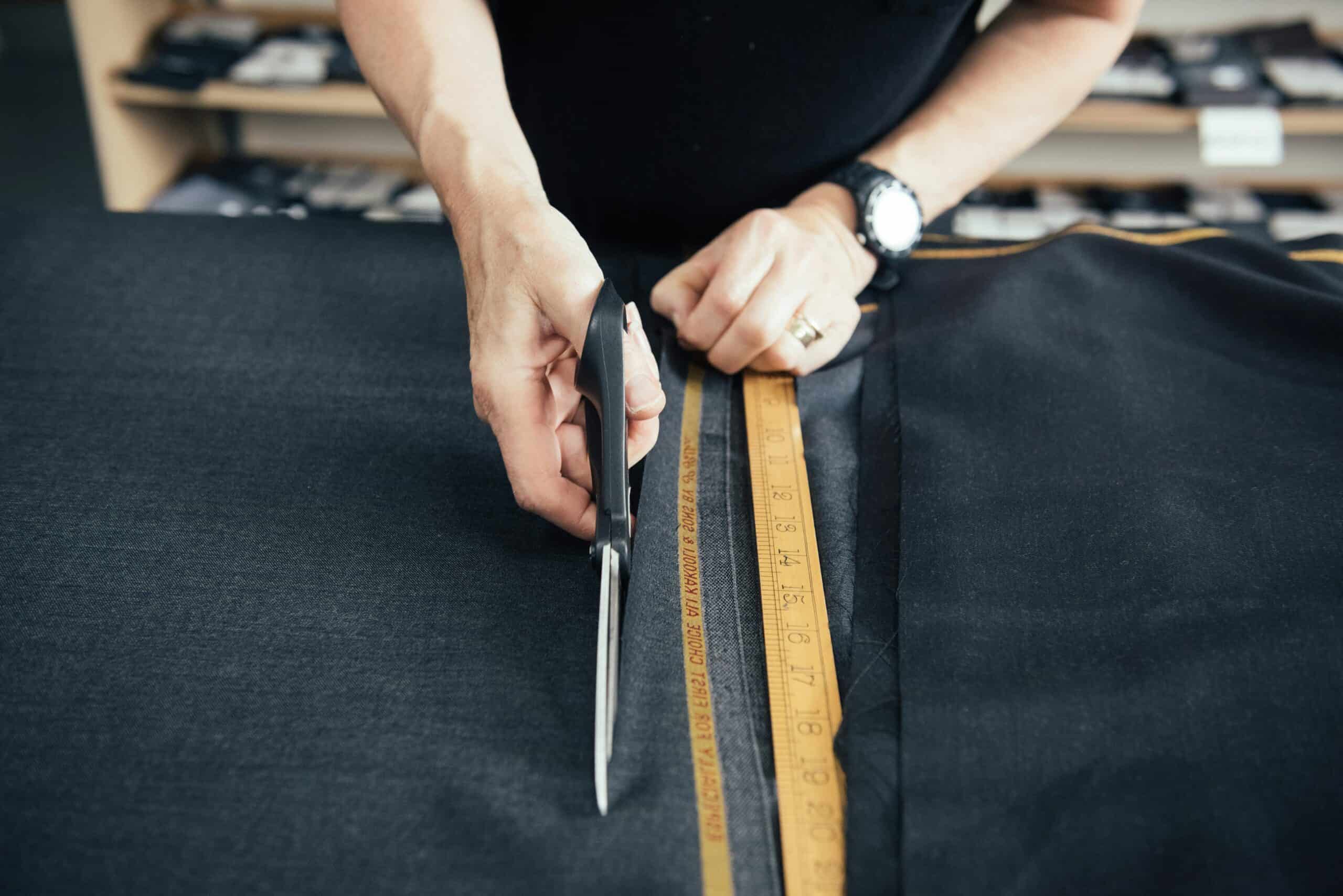 Tailor measuring fabric for custom sewing project.