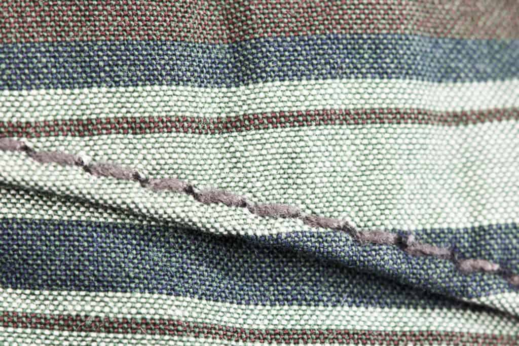 Close-up of striped fabric with visible stitching and textured weave.
